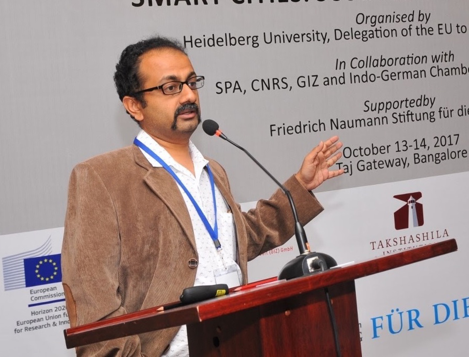 Sathya Sankaran speaking at the podium during a Heidelberg University Smart Cities event in Bangalore